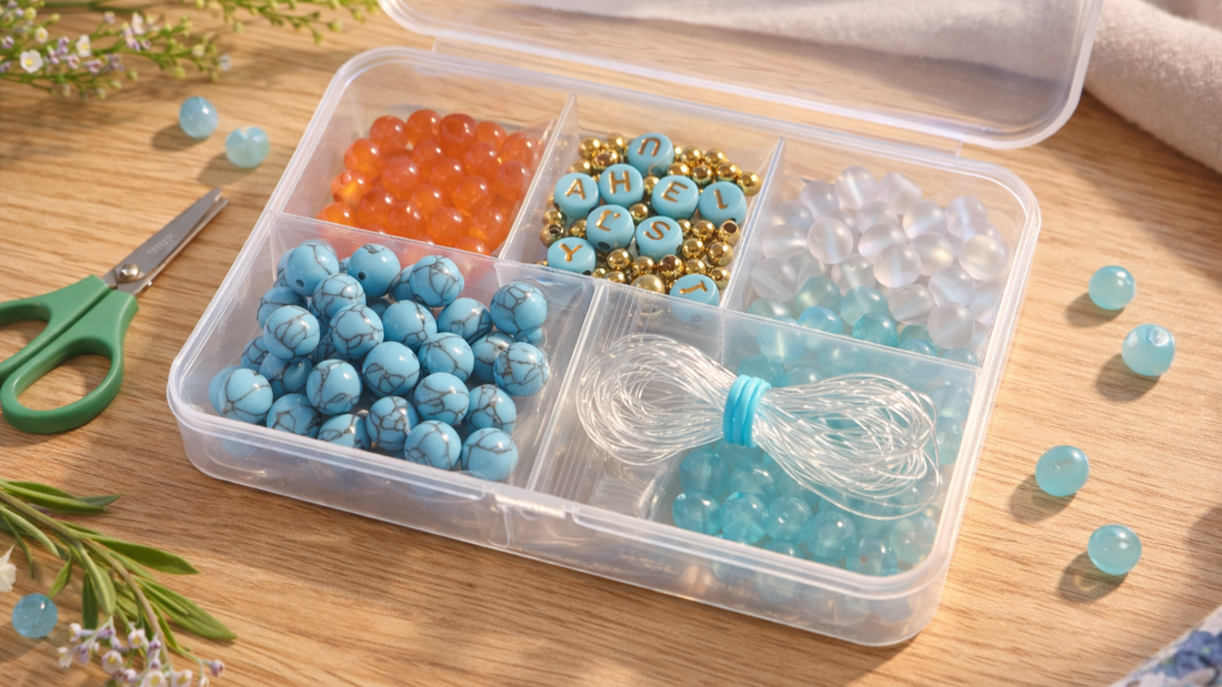 DIY bracelet making kit with colorful round beads, letter beads, stretch cord, and teal craft scissors neatly arranged in a clear organizer box on a light wooden table