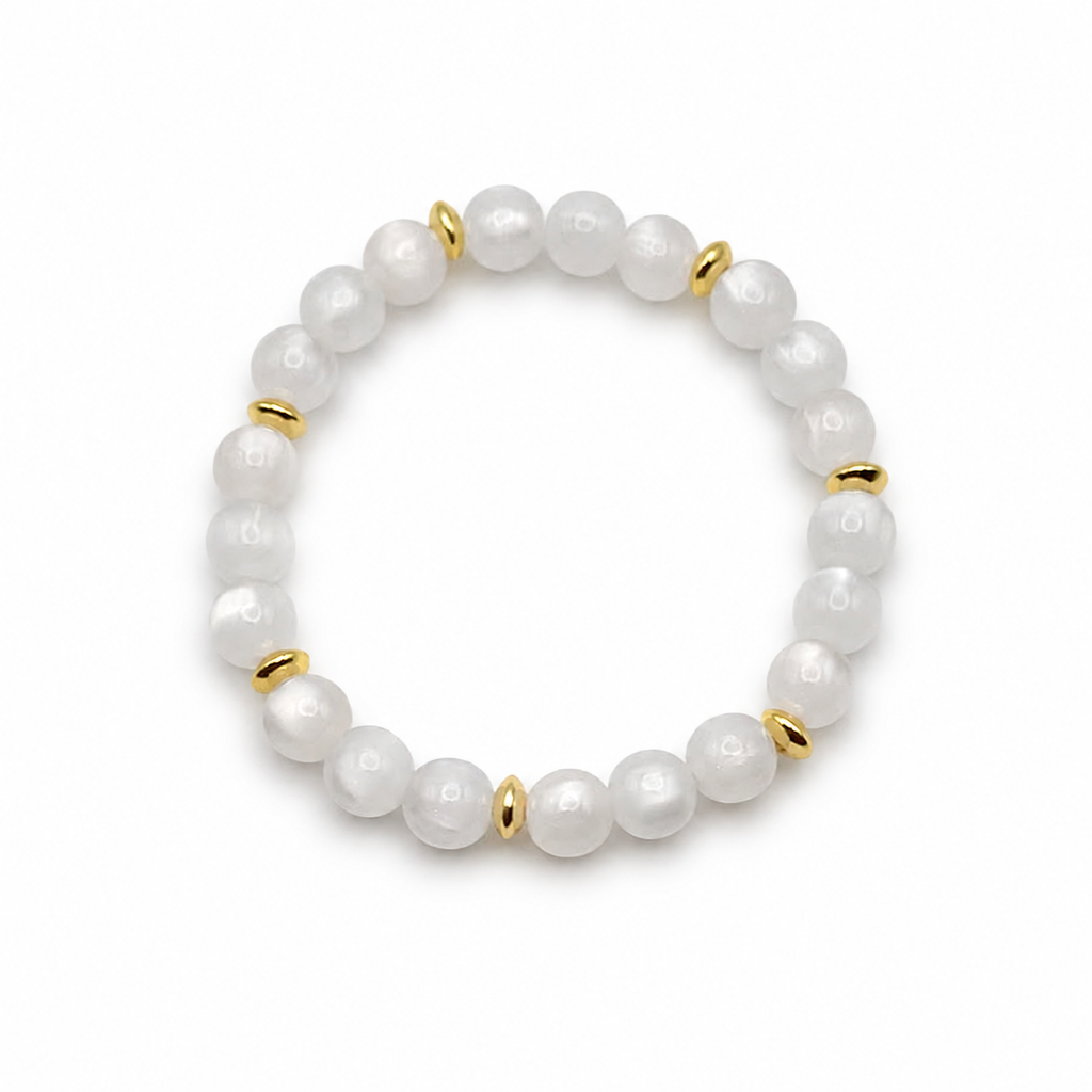 UV color changing bracelet with photochromic cat’s eye beads under room light, appearing cream-white with gold spacer beads and stretch cord