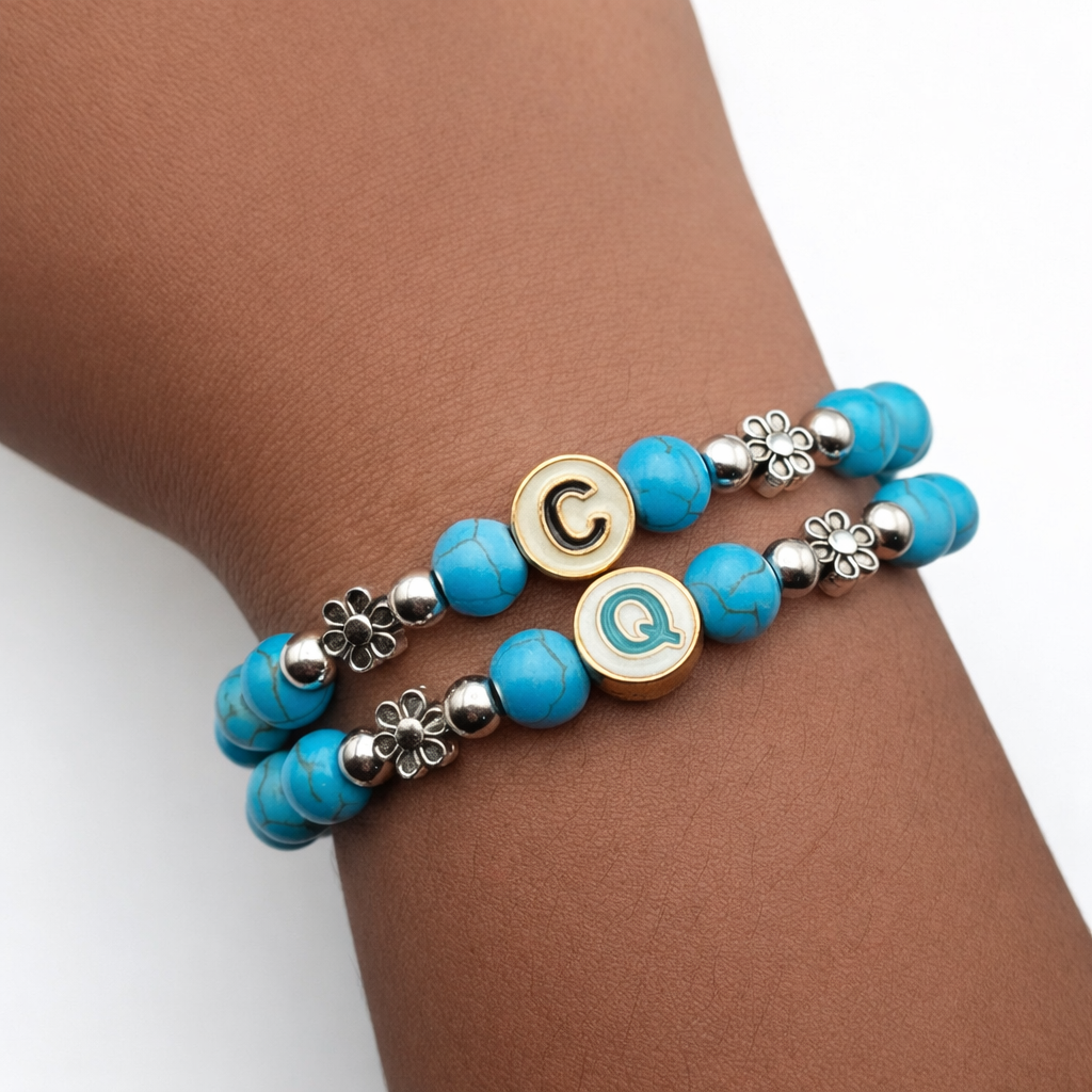 Turquoise marbled Howlite initial bracelets with metal flower spacers and letter charms worn stacked on wrist