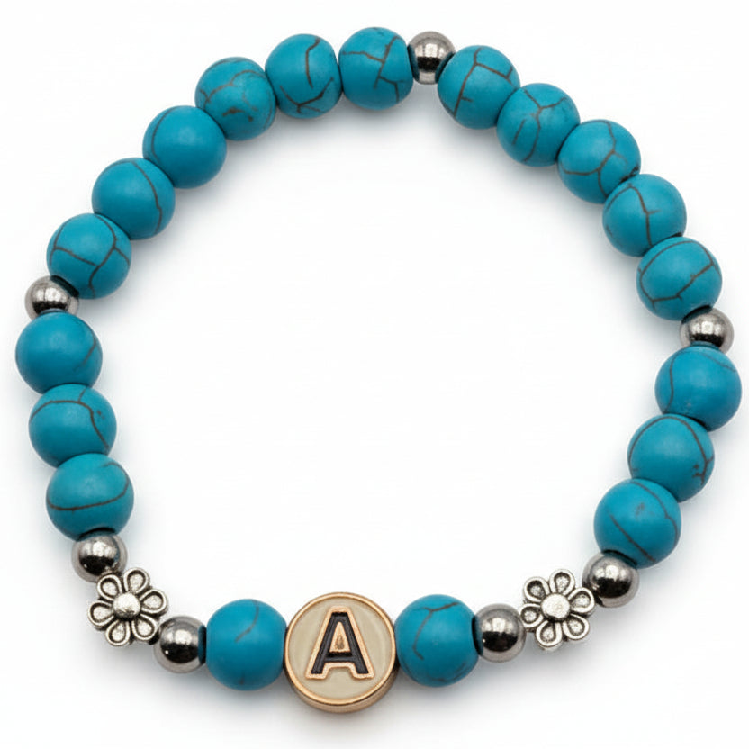 Turquoise marbled Howlite bead bracelet with gold letter charm and flower spacer accents on white background