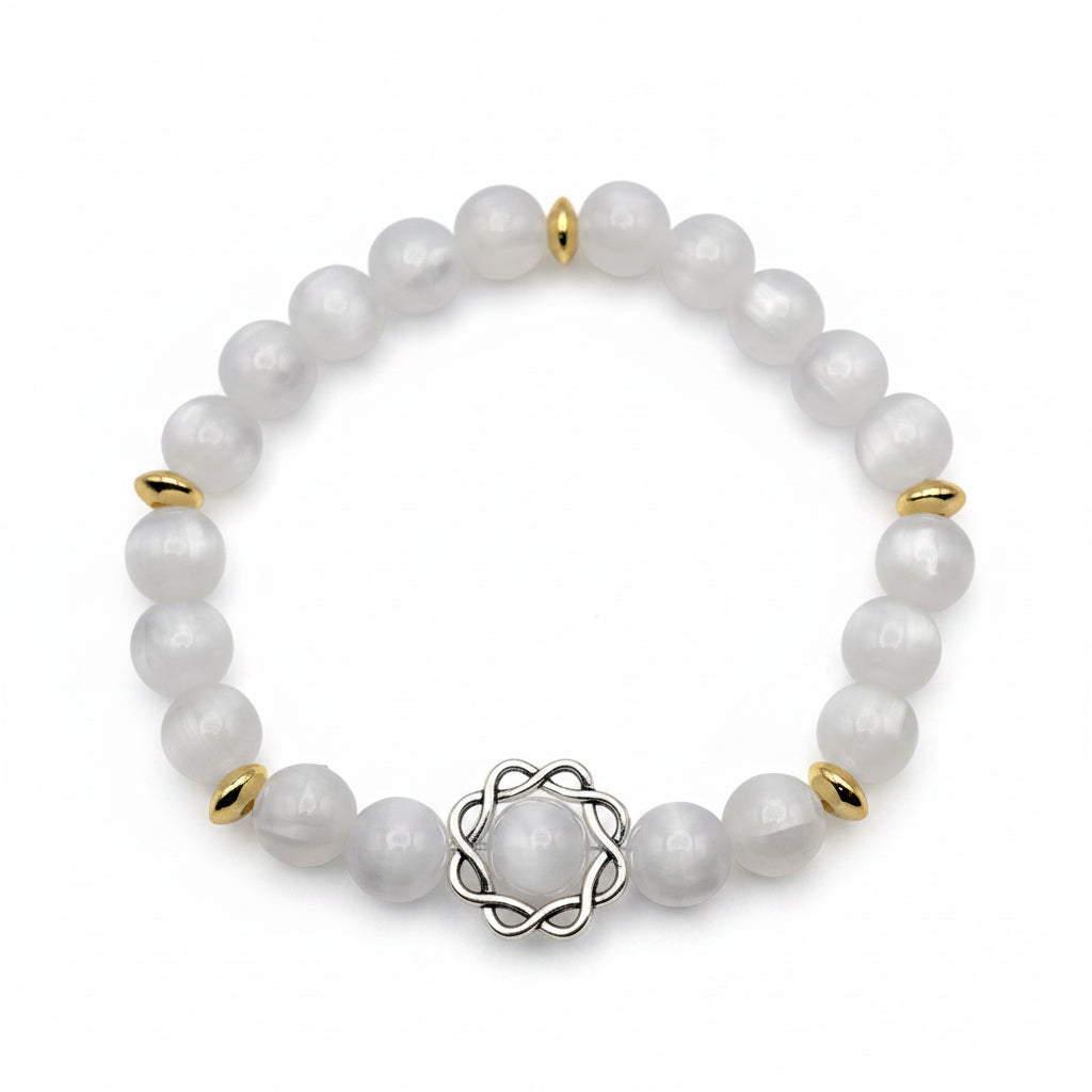 UV color changing bracelet with photochromic cat’s eye beads under room light, appearing cream-white with gold spacer beads, and decorative metal centerpiece