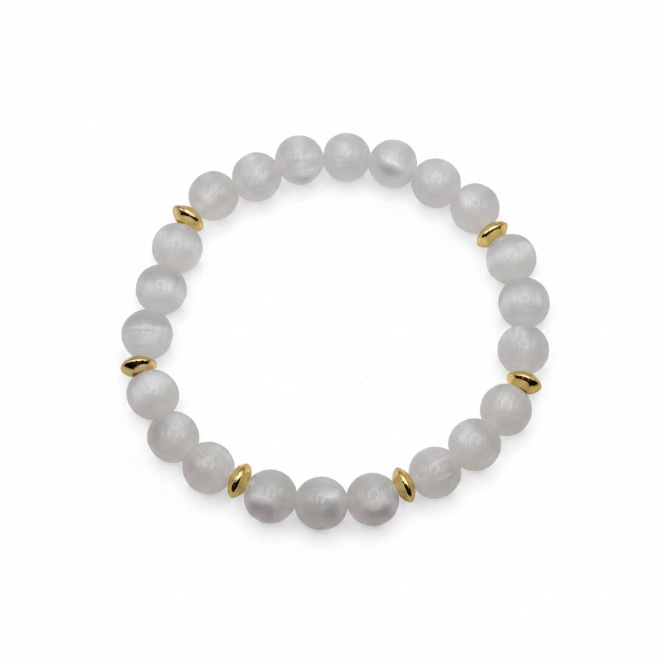UV color changing bracelet with photochromic cat’s eye beads under room light, appearing cream-white with gold spacer beads