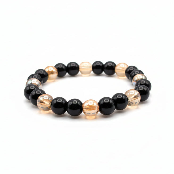 Black and golden 8mm glass bead stretch bracelet with glossy black beads and transparent golden-toned beads in a two-color design