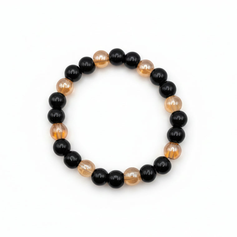 Black and golden 8mm glass bead stretch bracelet with glossy black beads and transparent golden-toned beads in a two-color design
