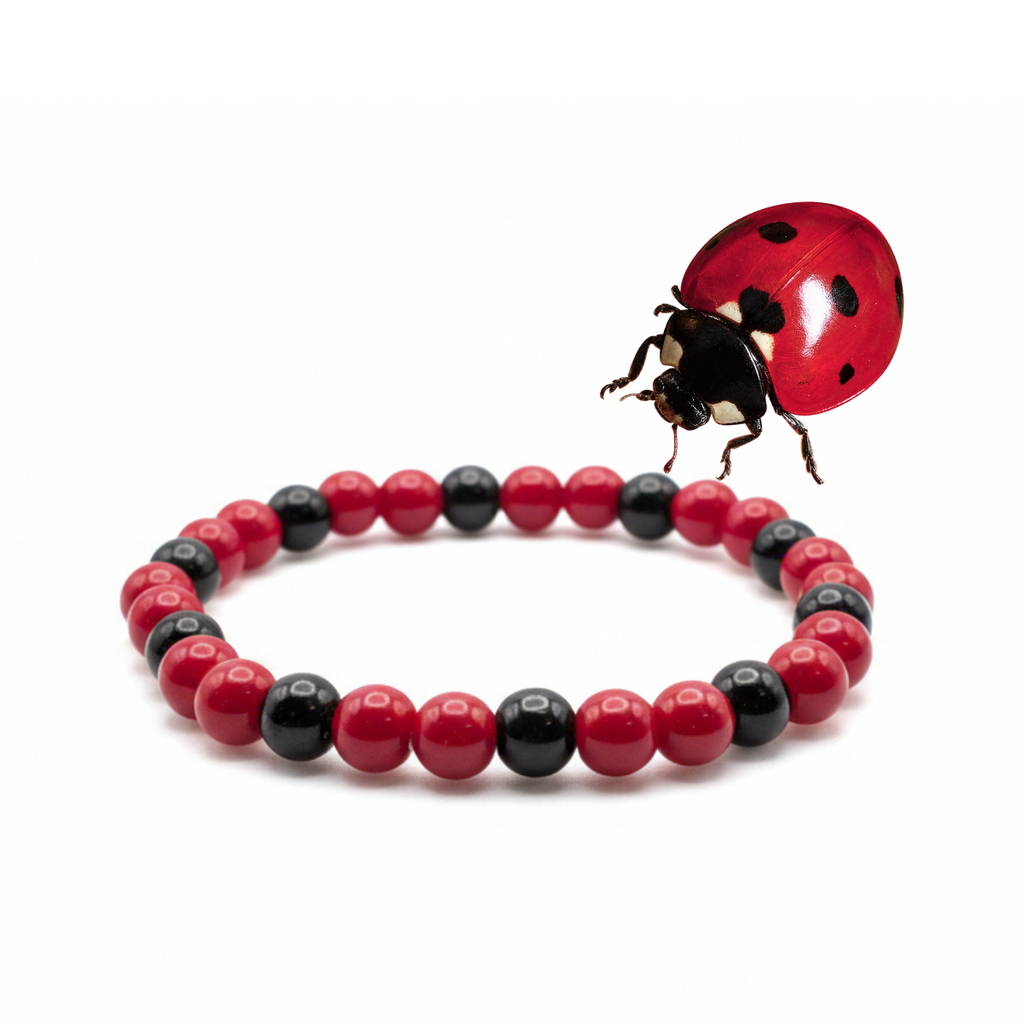 Little Ladybug red and black glass bead bracelet displayed with a real ladybug